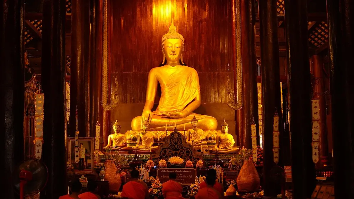 Buddhist monks worshipping a Buddha statue