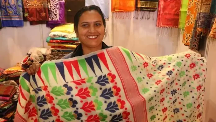 A woman shopkeeper showcasing her products at SARAS Aajeevika Mela, Pragati Maidan, New Delhi